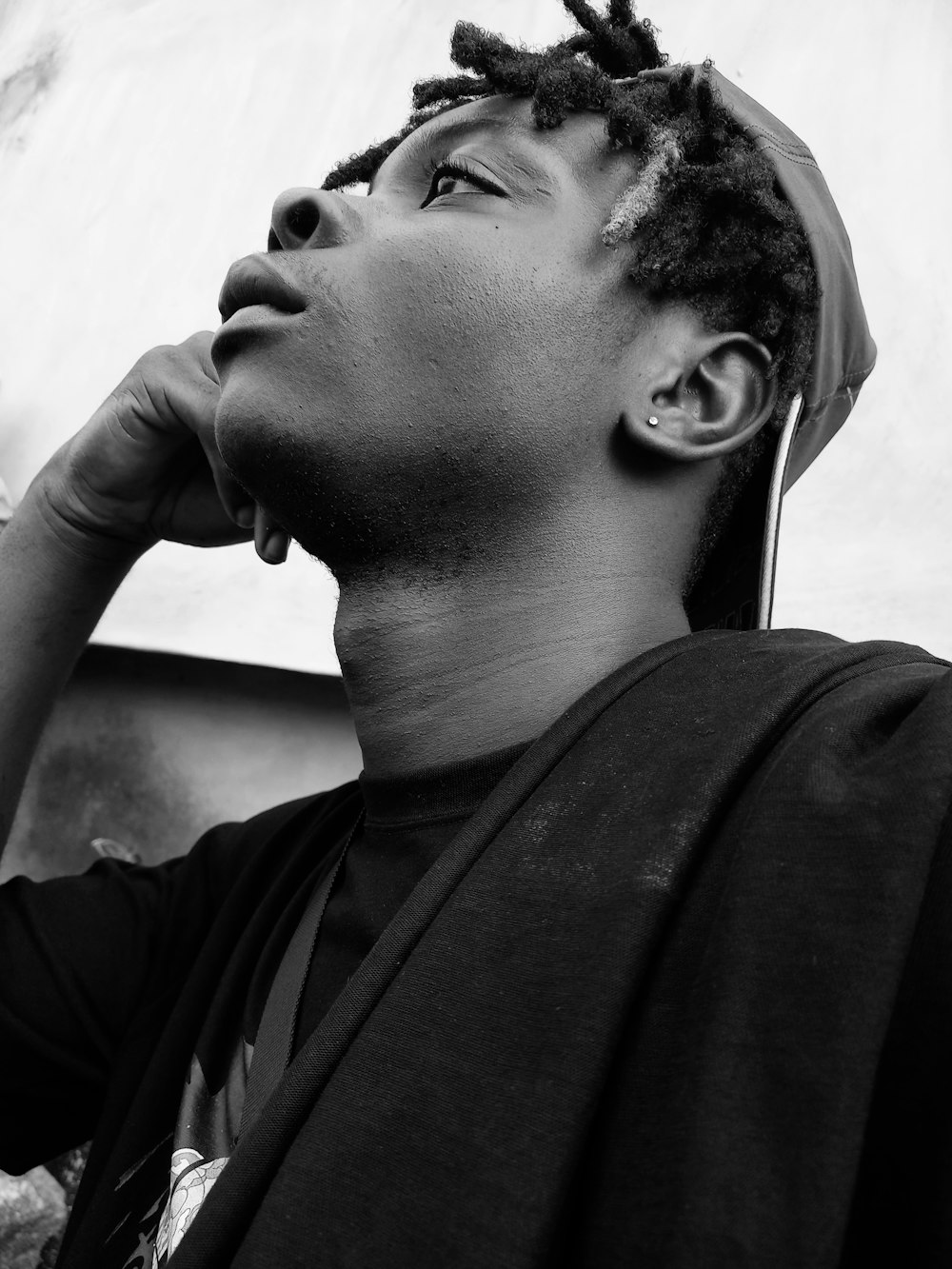 a black and white photo of a man with dreadlocks