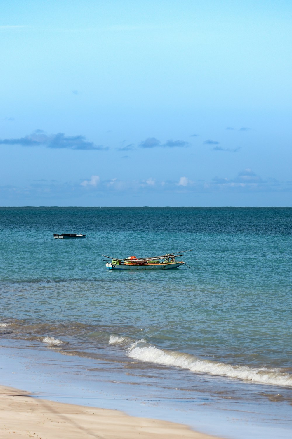 a couple of boats floating on top of a body of water