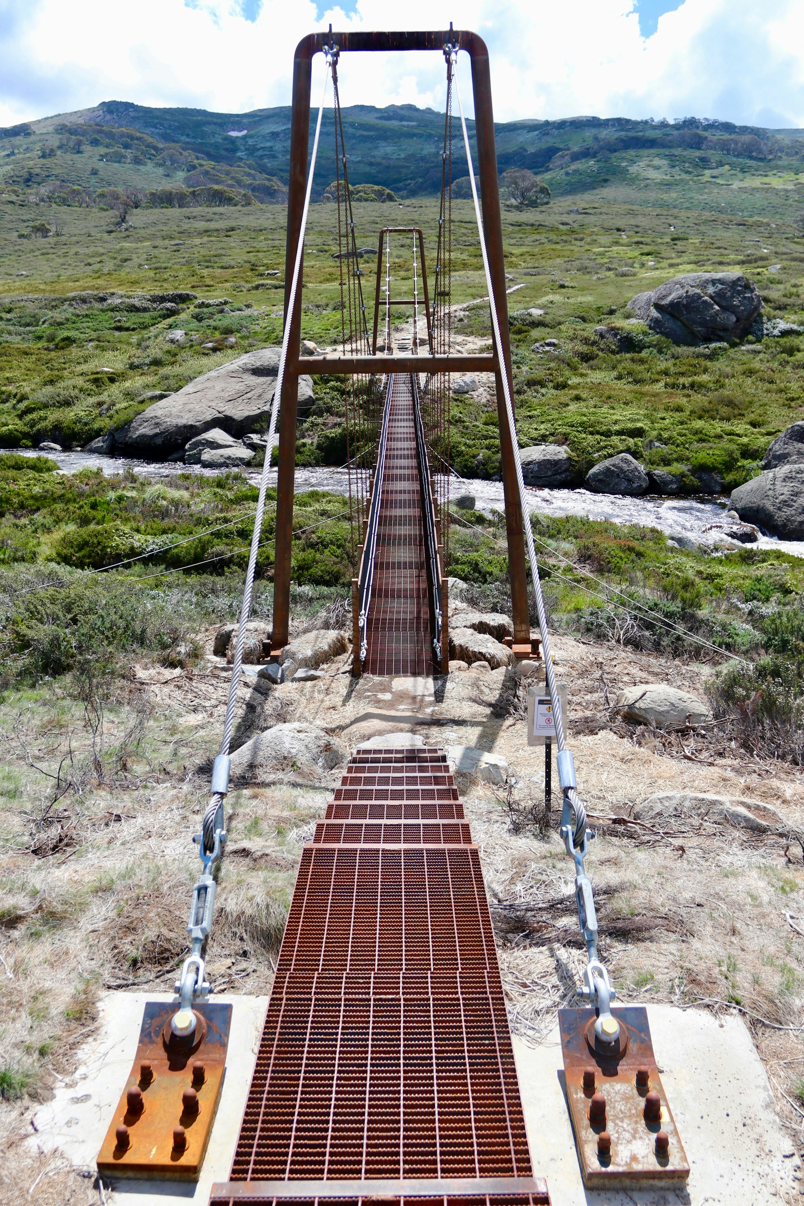 eine sehr lange Metallbrücke mitten auf einem Feld