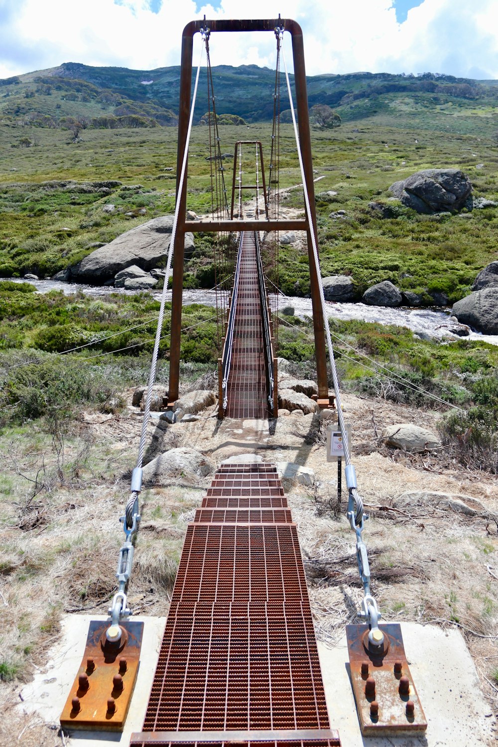 a very long metal bridge in the middle of a field