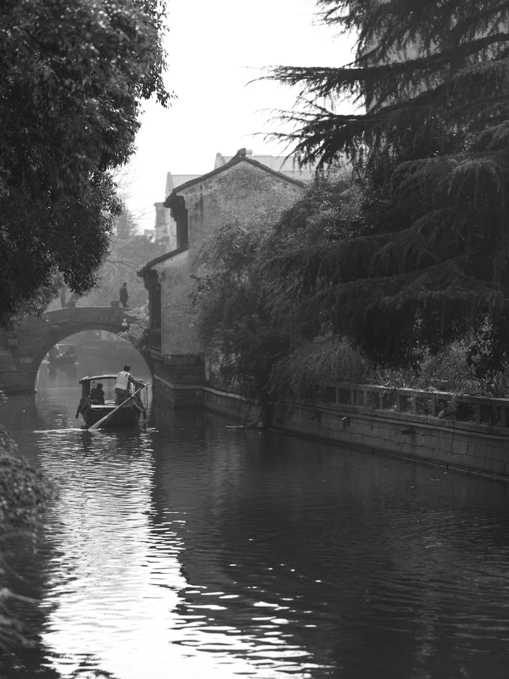 a boat traveling down a river next to a bridge