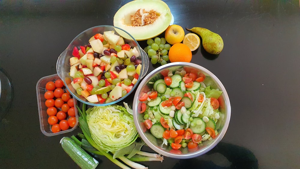 a table topped with bowls of vegetables and fruit