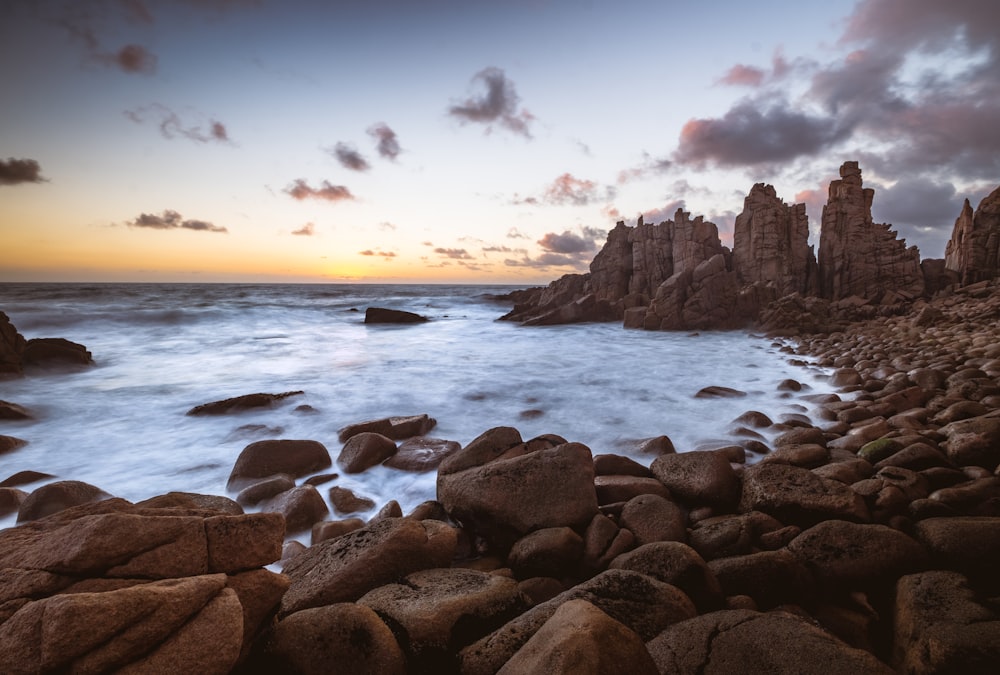 a rocky shore line with a body of water