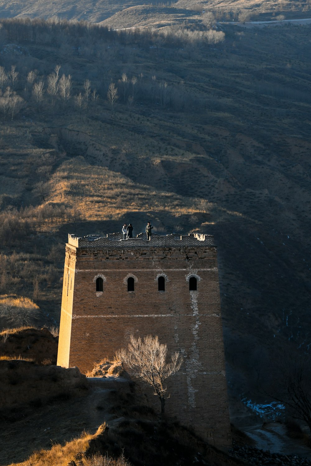 a tall brick tower sitting on top of a hill