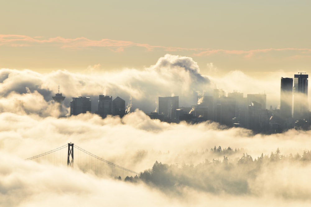 a view of a foggy city with a bridge in the foreground