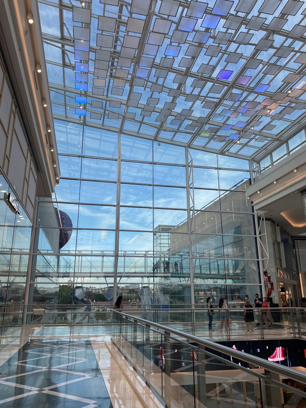 a large glass building with people inside of it