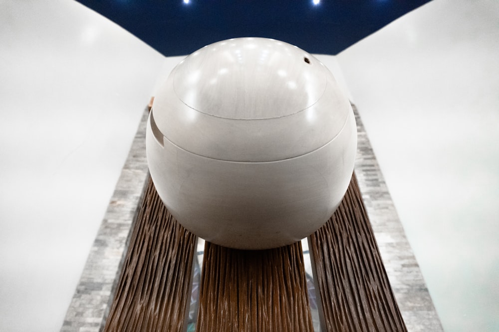uma grande bola branca sentada no topo de uma plataforma de madeira