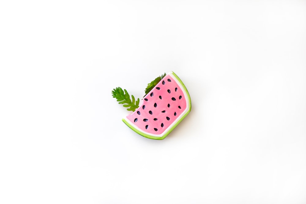 a watermelon slice with a green leaf on top of it