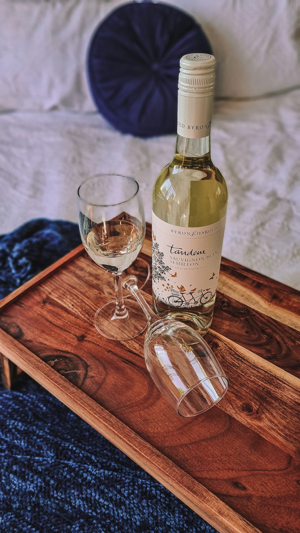 a bottle of wine sitting on top of a wooden tray