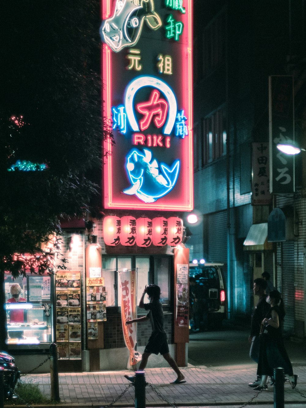 a person walking down a street at night