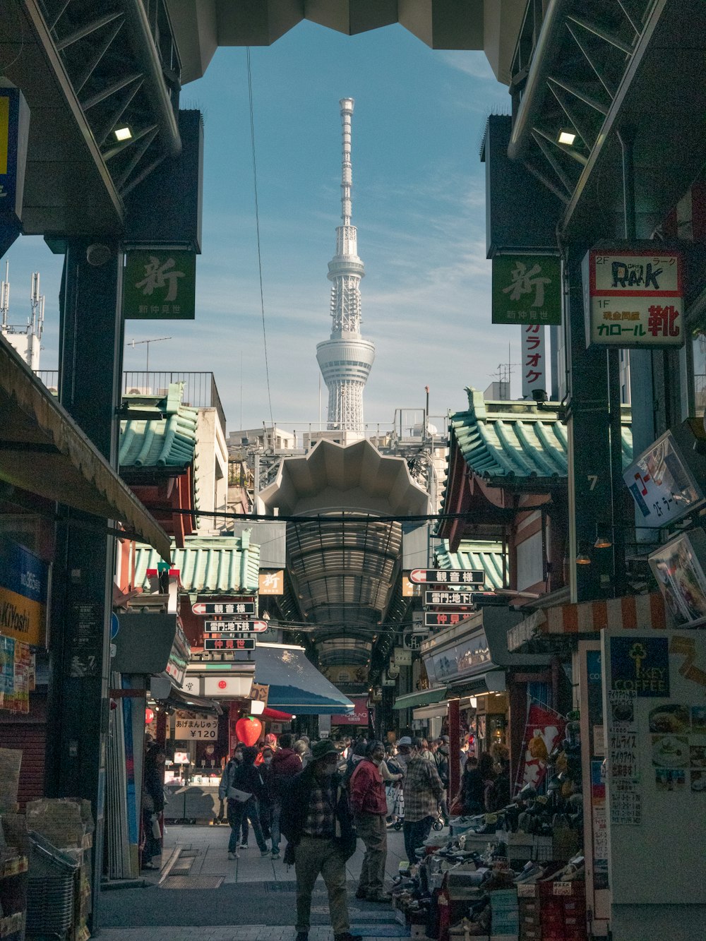 a city street with shops and a tall building in the background