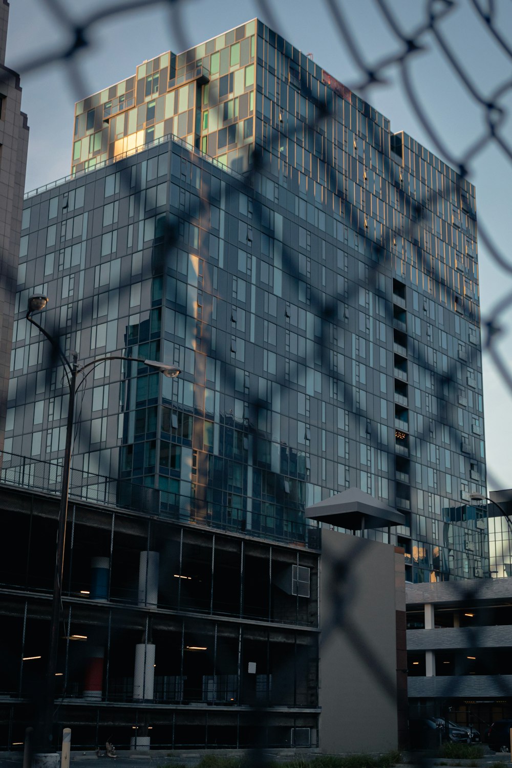 a tall building behind a chain link fence