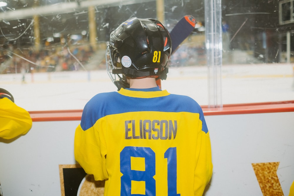 a hockey player wearing a yellow and blue uniform