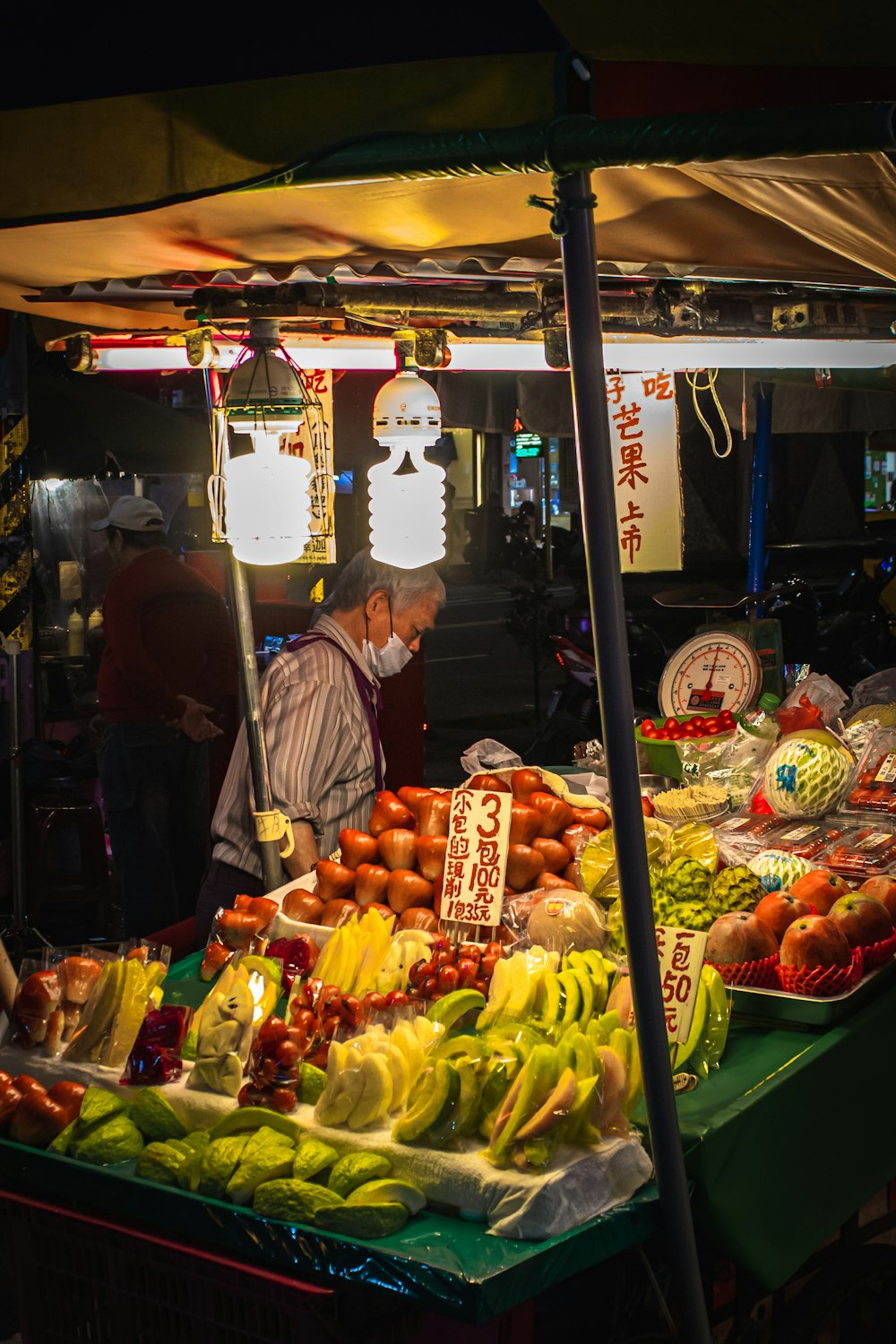 a man standing in front of a fruit stand