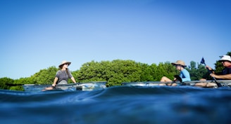 Picture of a group of kayakers paddling near a sunny spoil island on a clear morning.