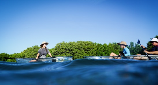 Picture of a group of kayakers paddling near a sunny spoil island on a clear morning.