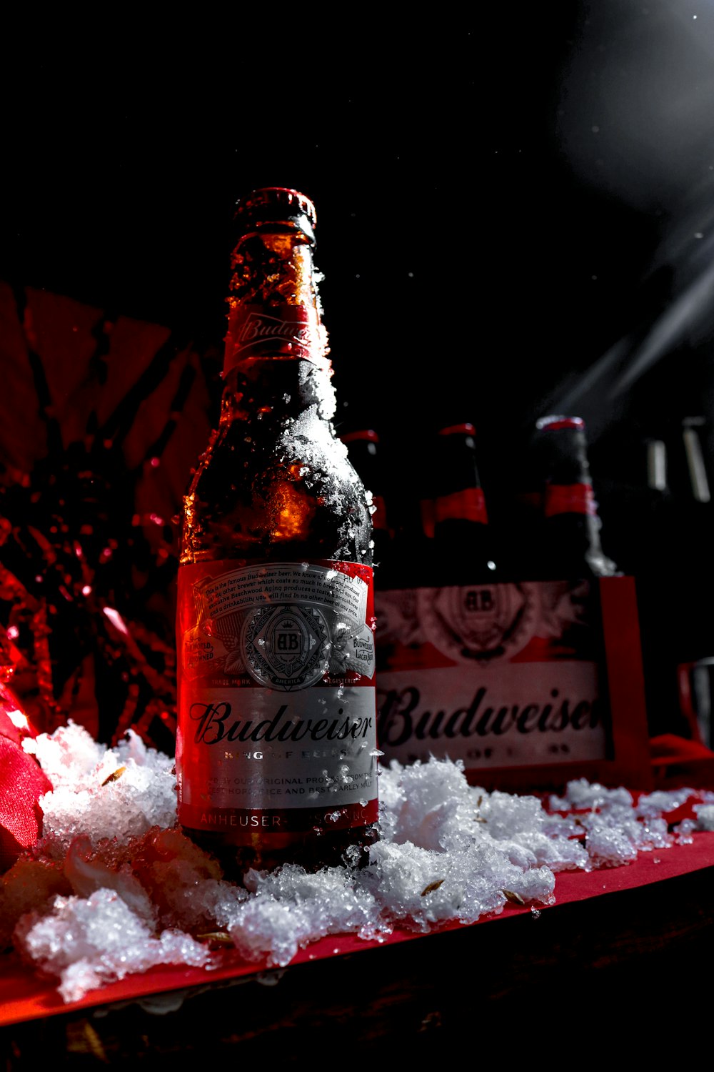 a bottle of beer sitting on top of a table covered in snow
