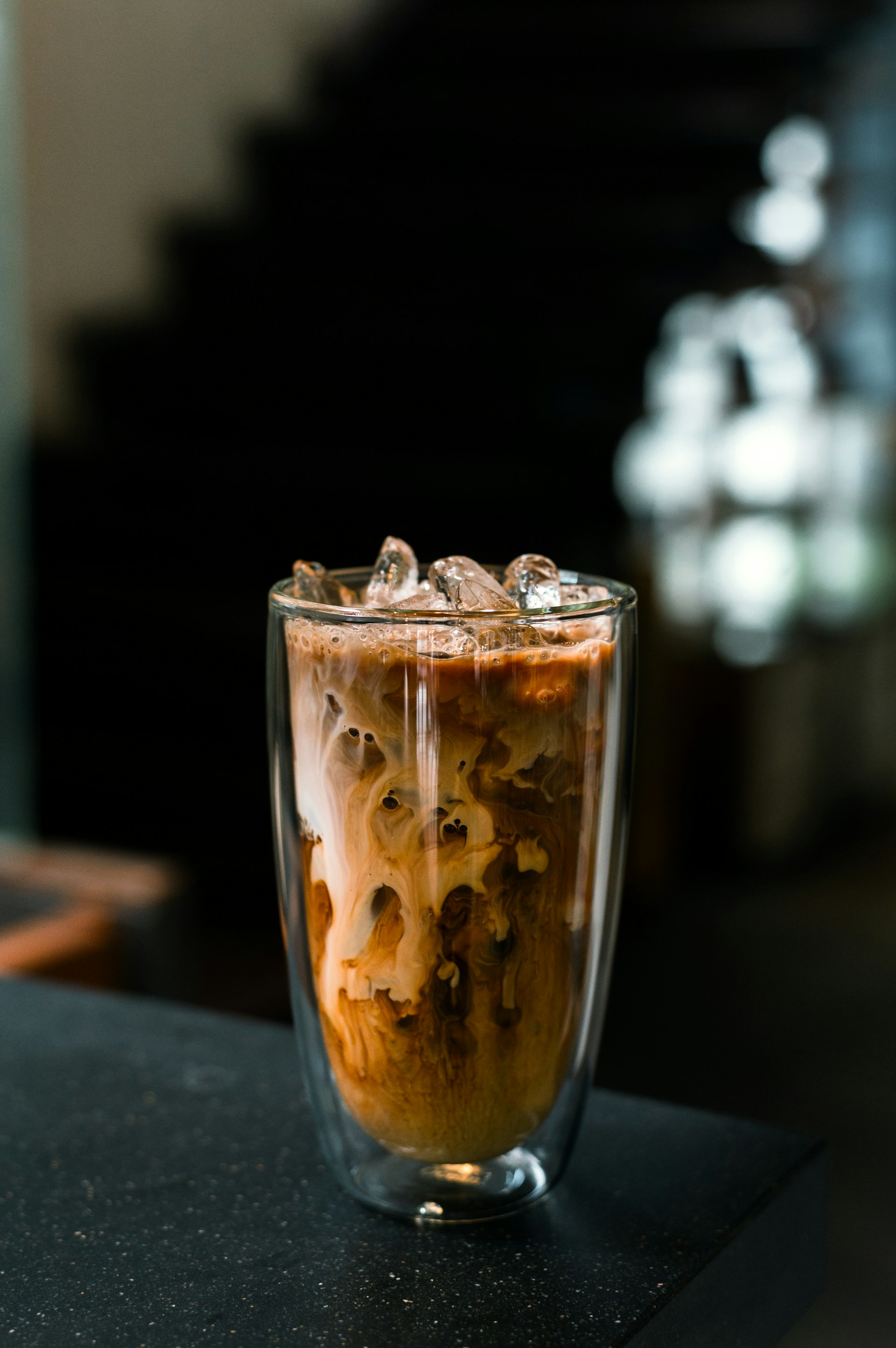 a glass filled with liquid and ice on top of a table