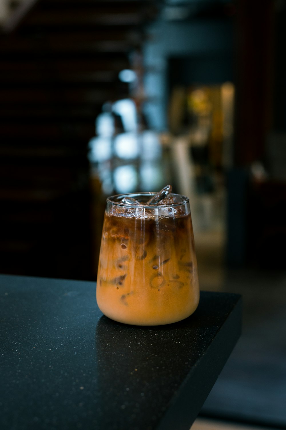 a glass filled with liquid sitting on top of a counter