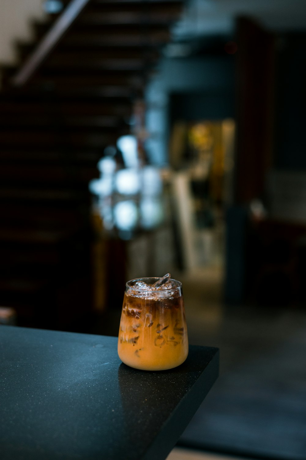 a glass filled with liquid sitting on top of a table