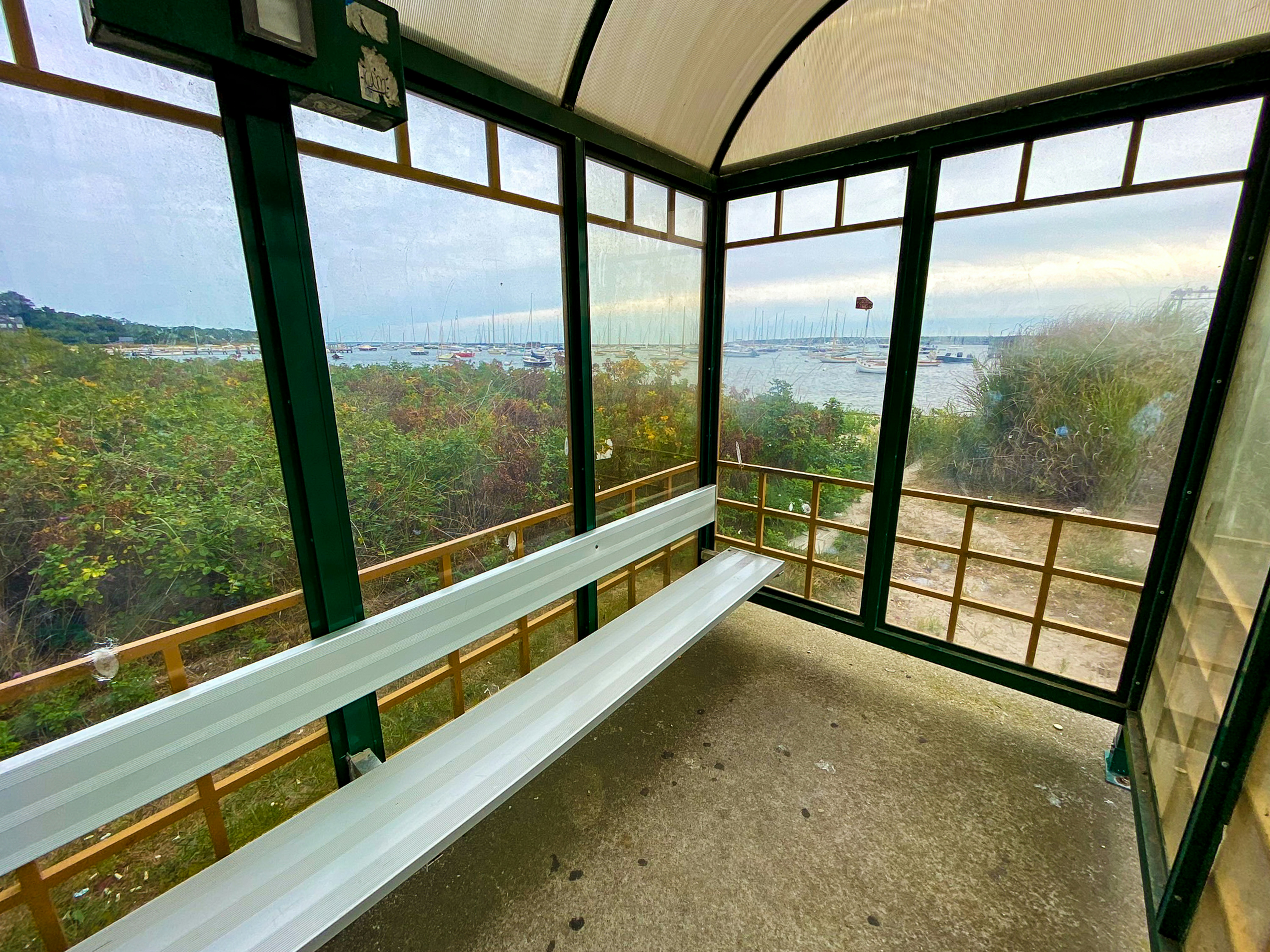 A white bench sitting inside of a glass enclosed room photo – Free ...