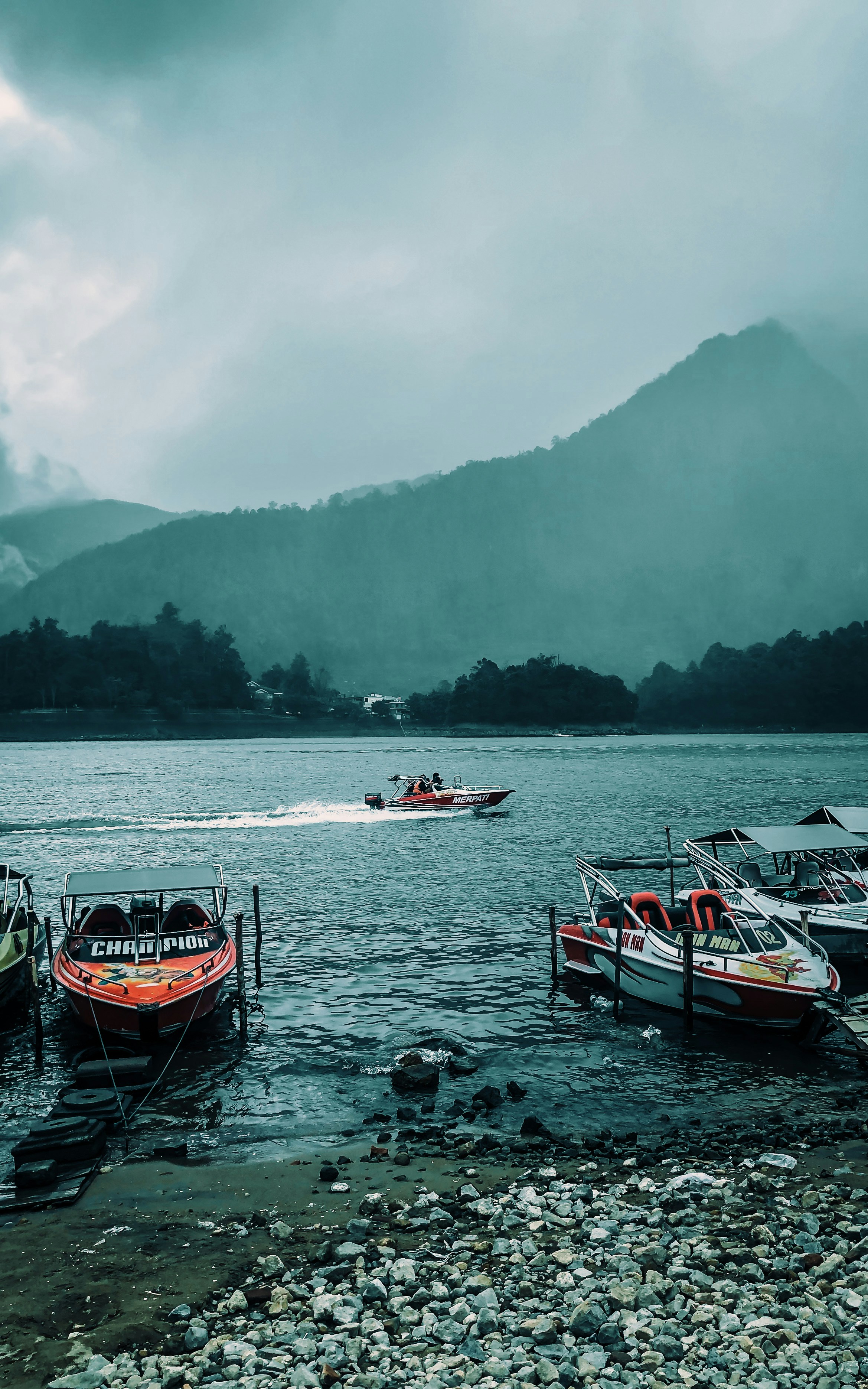 Un gruppo di barche galleggianti sulla cima di un lago