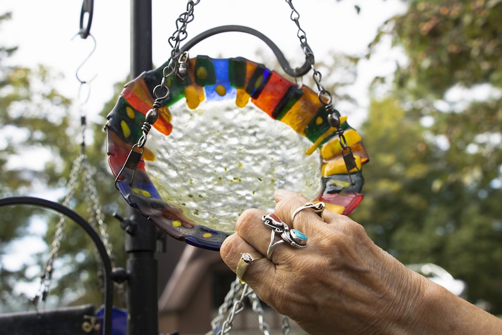 a person holding a colorful glass plate in their hand
