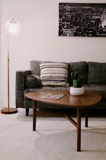 Overhead shot of a modern living room setup featuring a charcoal sofa and matching coffee table with gold accents.