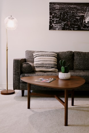 Overhead shot of a modern living room setup featuring a charcoal sofa and matching coffee table with gold accents.