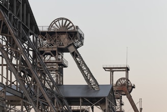 a very tall metal structure with a clock on it's side