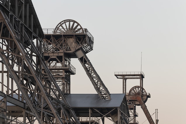 a very tall metal structure with a clock on it's side