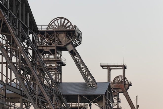 a very tall metal structure with a clock on it's side