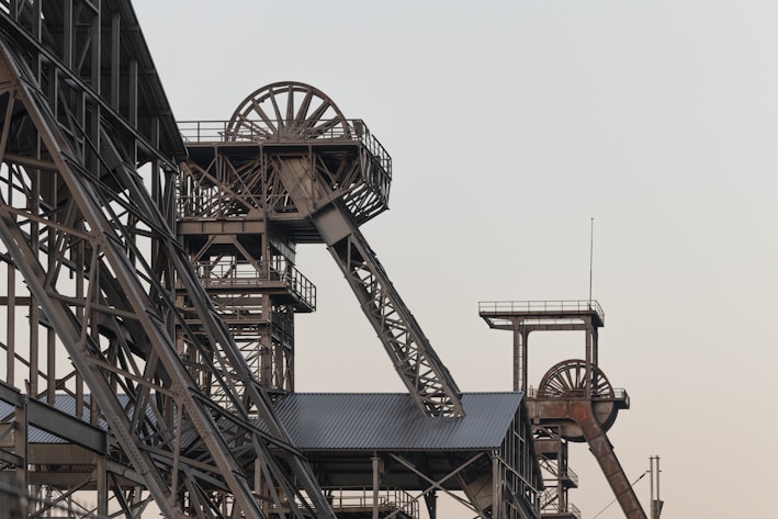 a very tall metal structure with a clock on it's side