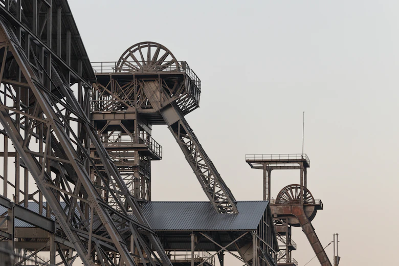 a very tall metal structure with a clock on it's side
