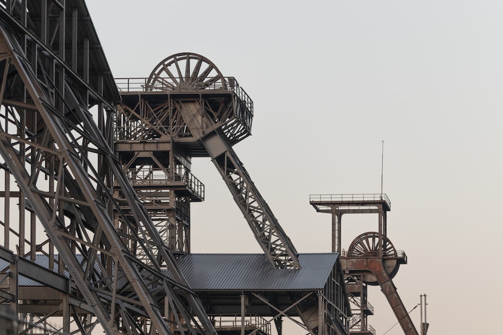 a very tall metal structure with a clock on it's side