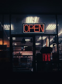 a neon open sign in the window of a store