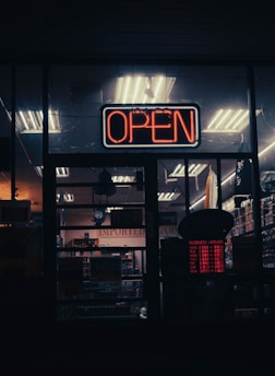 a neon open sign in the window of a store