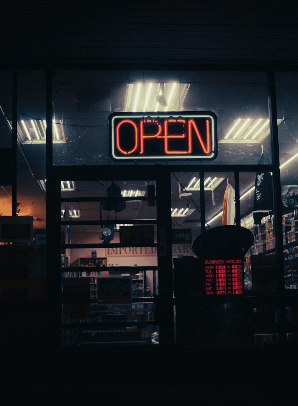 a neon open sign in the window of a store