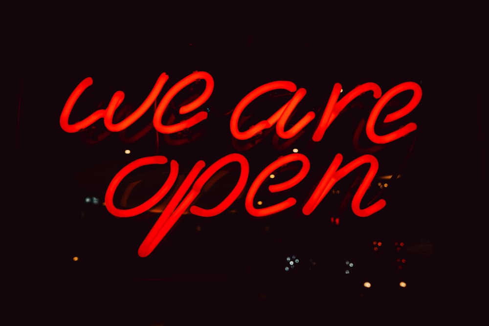 a neon sign that says we are open