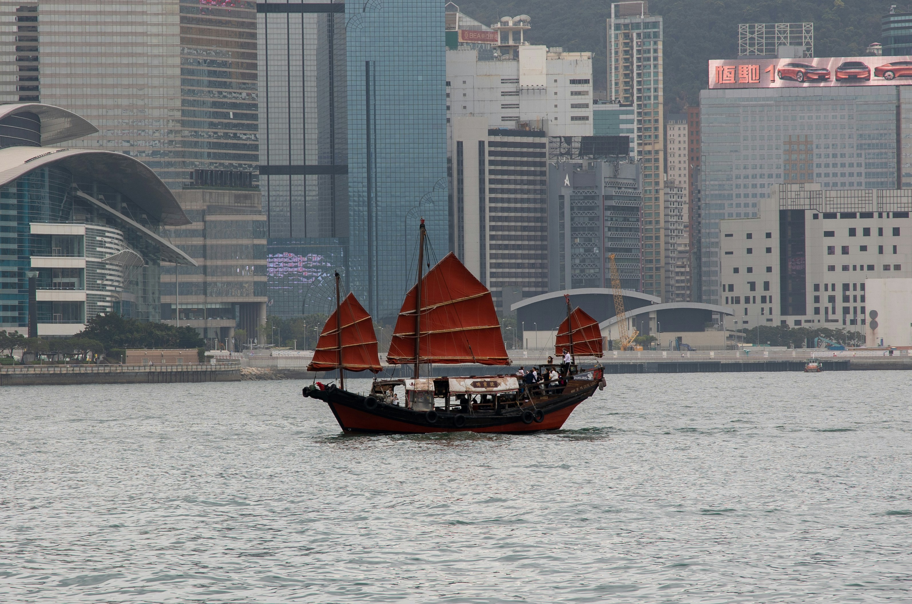 a boat with red sails in a body of water