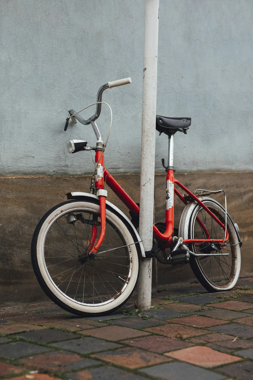 a red bicycle is leaning against a pole