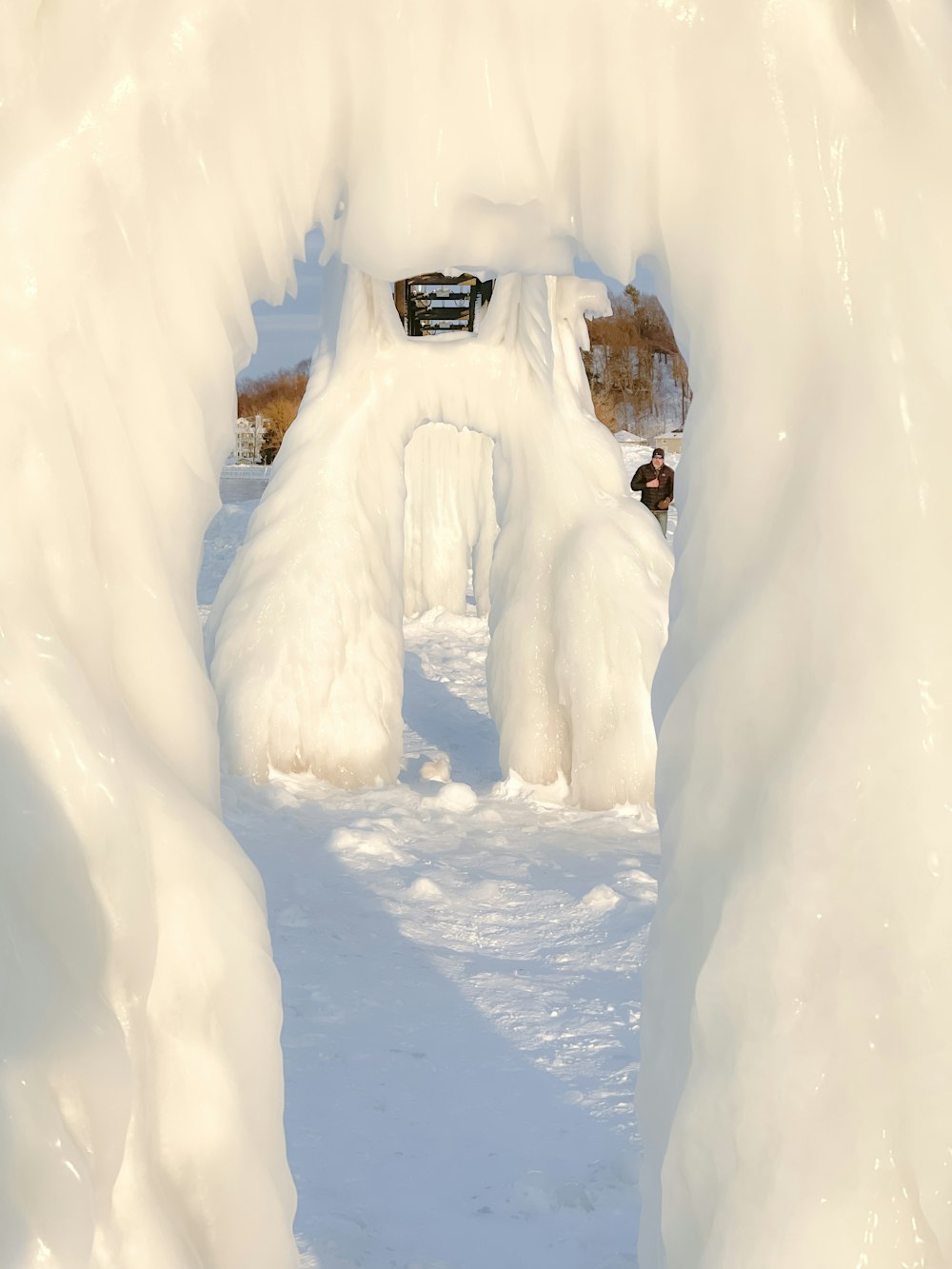 a snow covered tunnel with a bench in the middle of it
