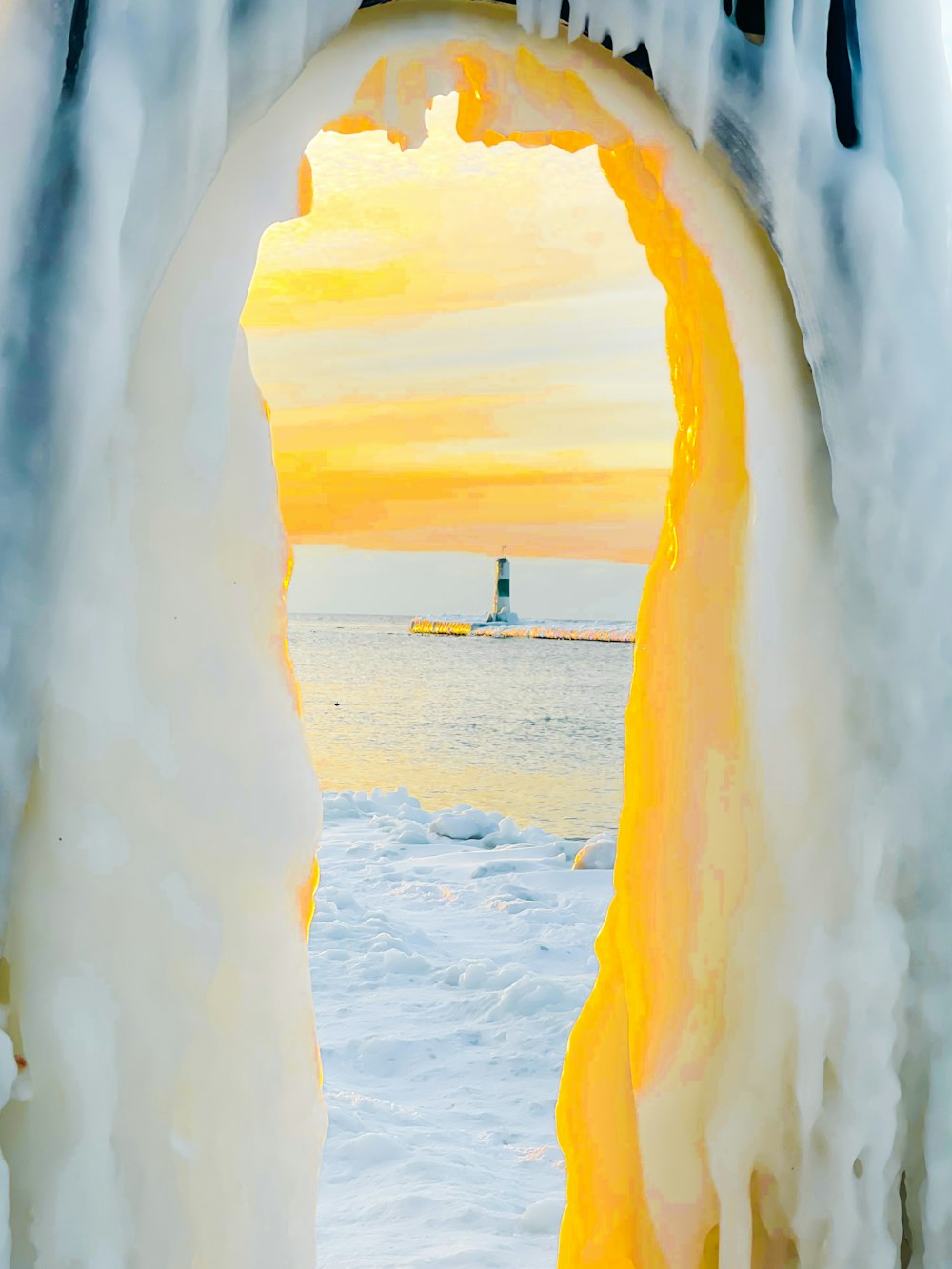 an ice cave with a lighthouse in the distance