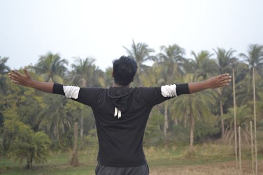 a man standing in a field with his arms outstretched