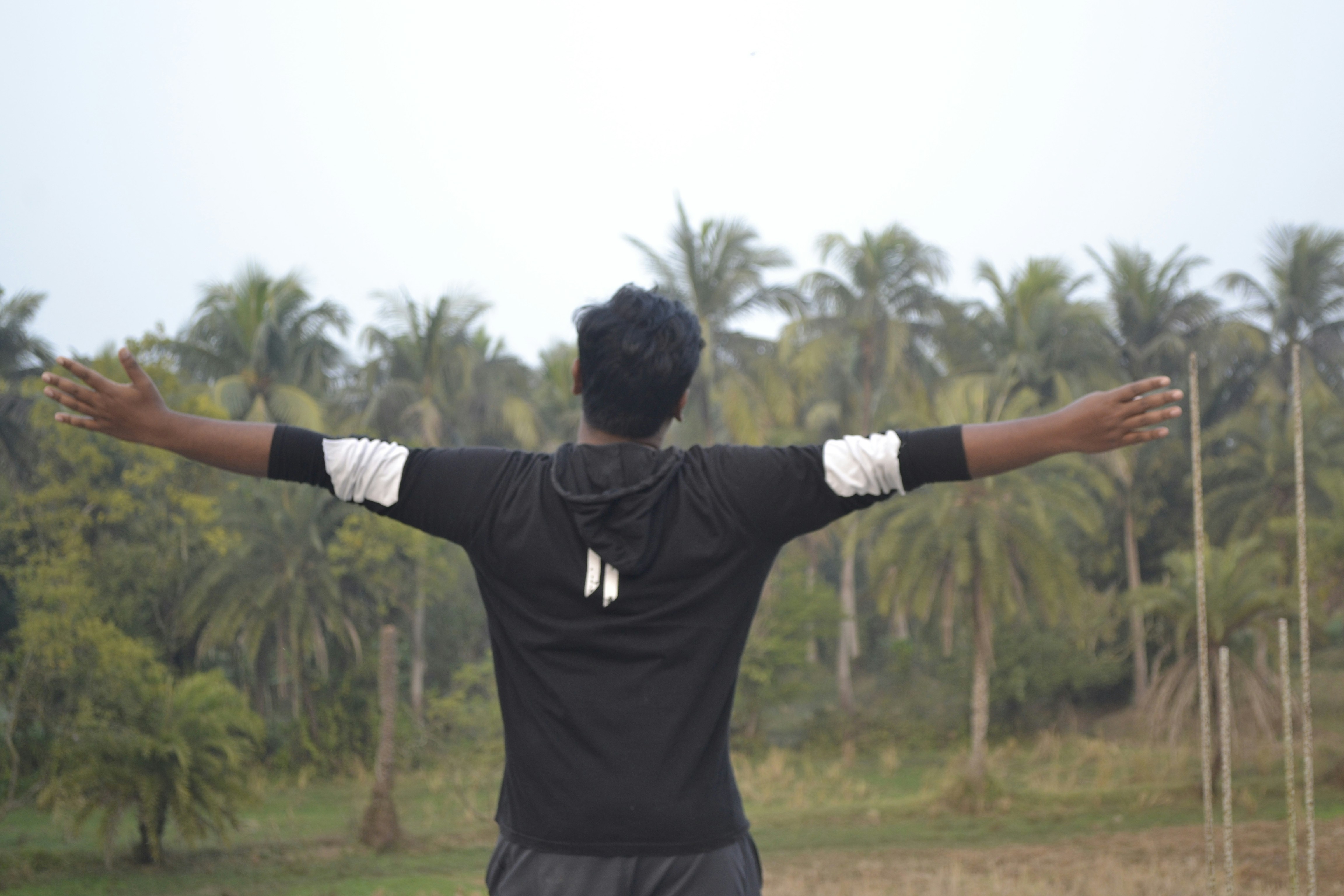 a man standing in a field with his arms outstretched