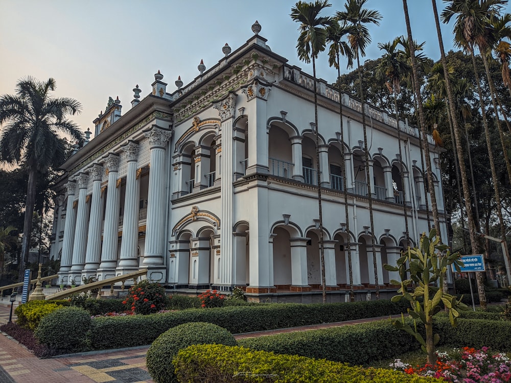 a large white building surrounded by palm trees