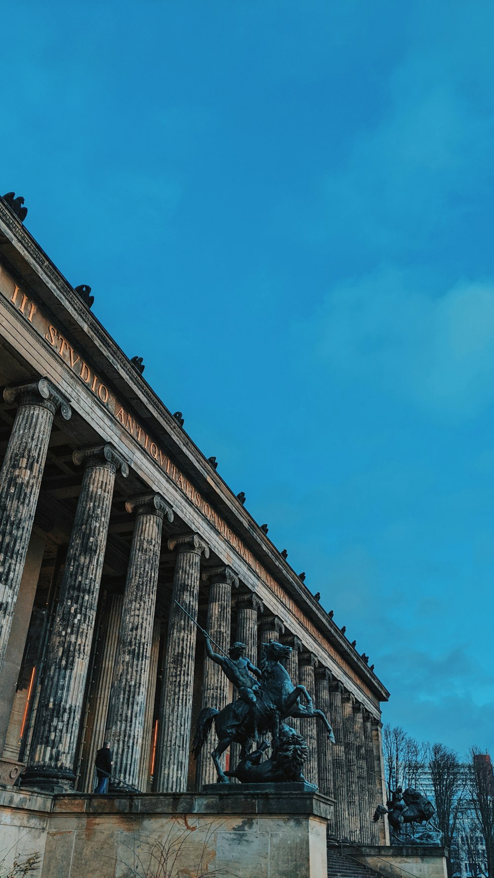 a building with columns and a statue on top of it