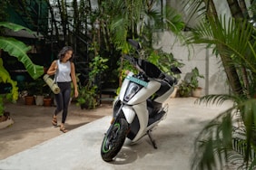 a woman walking next to a parked motorcycle