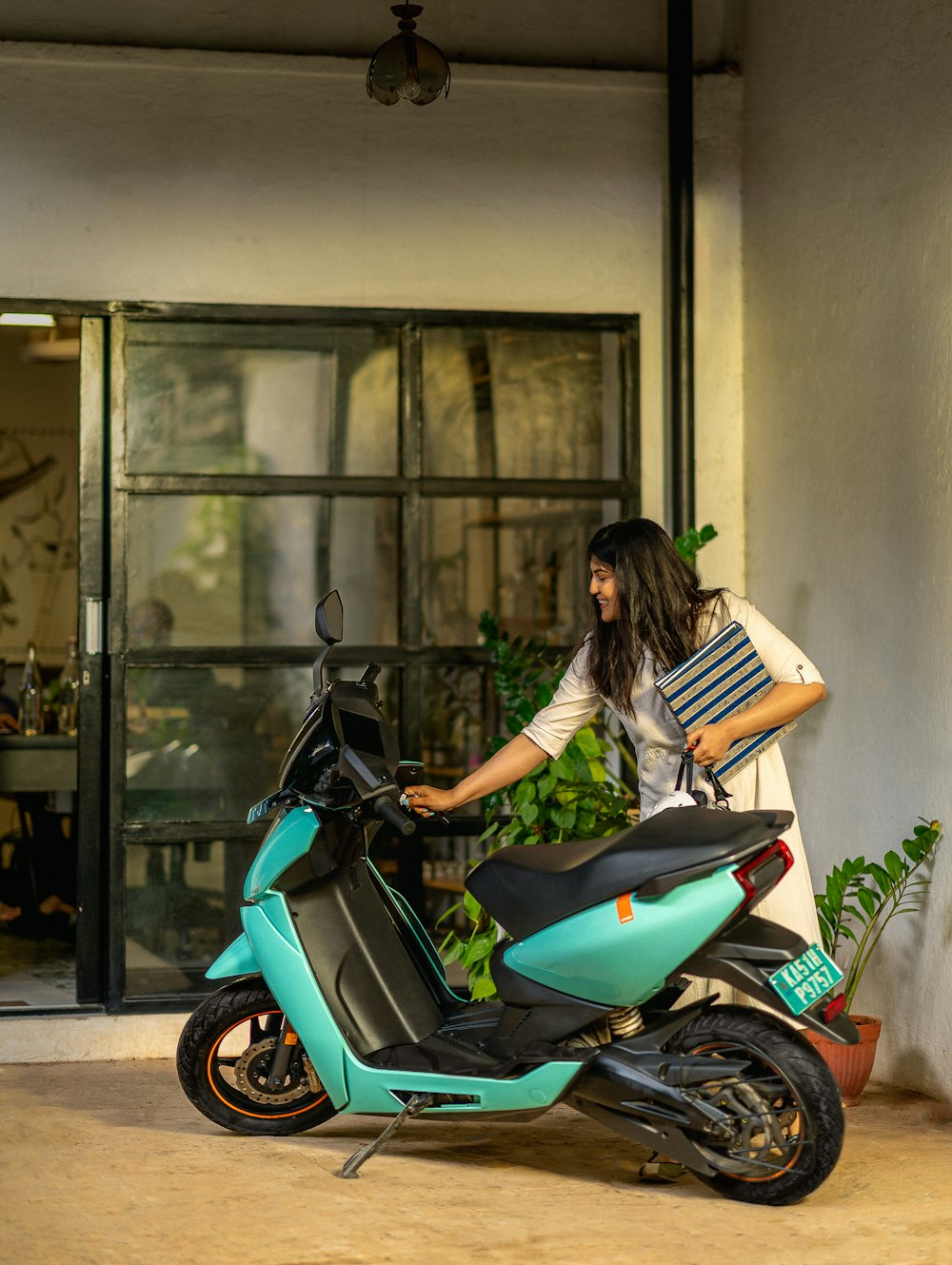 a woman standing next to a blue scooter