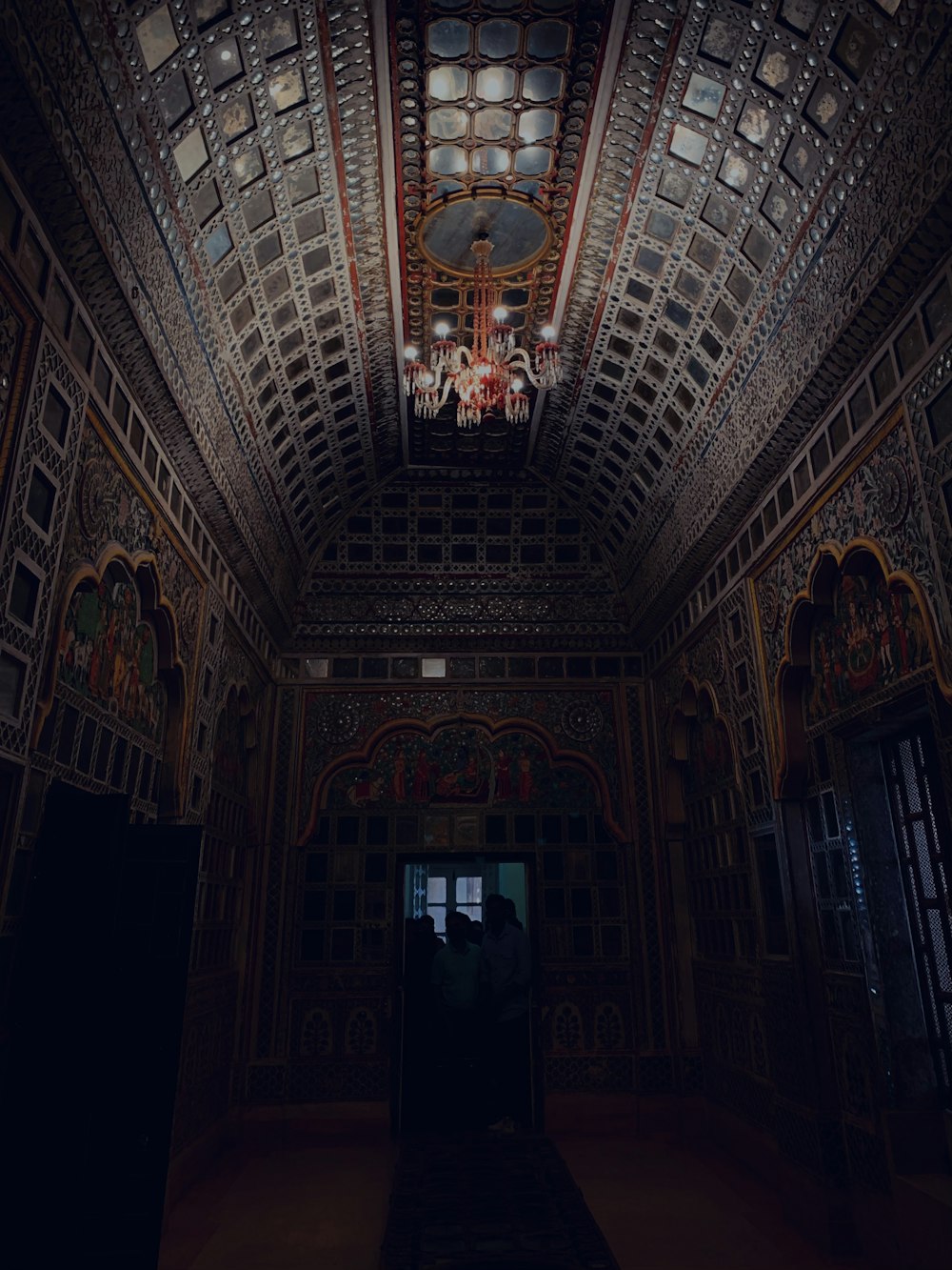 a dark room with a chandelier hanging from the ceiling